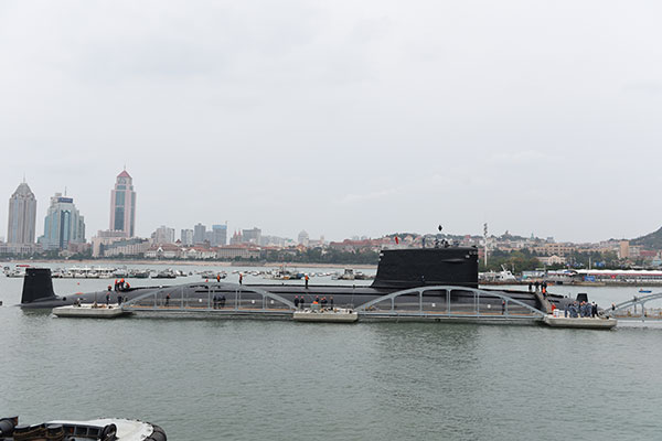  在拖船的拖带下，我国首艘退役核�芵札a泊在位于青岛的海军博物馆码头。
