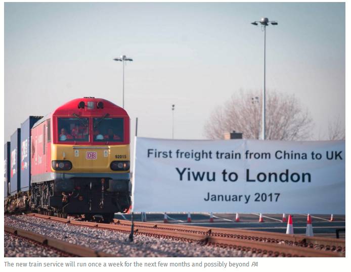 火车进站的终点线上，一个横幅写着「历史首列从中国到英国的列车」。