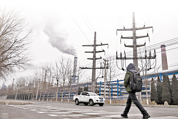 ■減排是治霾的關鍵。圖為大連市民路過一家正在排放濃煙的工廠。資料圖片