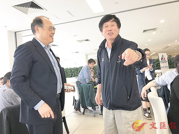 ■單車隊總教練沈金康（右）向林大輝介紹情況。 潘志南  攝