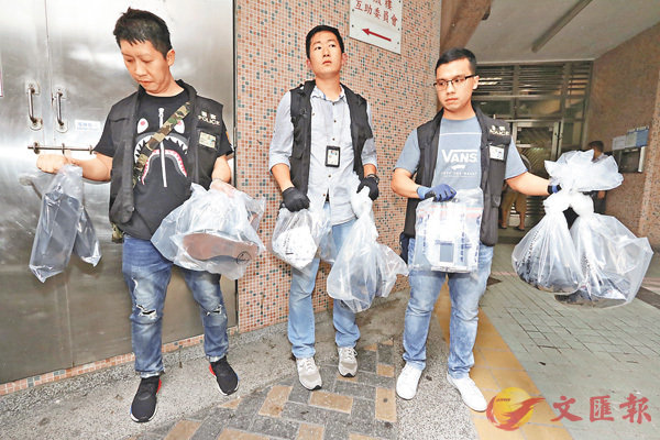 ■探員在疑犯寓所檢走一批證物。 劉友光 攝