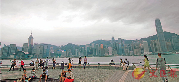 ■「卡努」「打到�薄v，仍有不少市民在尖沙咀冒風拍照。 香港文匯報記者彭子文  攝