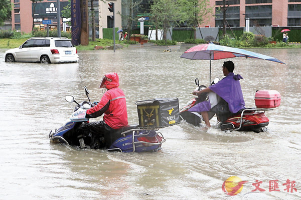 ■7月2日，四川省成都市遭暴雨襲擊。圖為成都市民騎行在積水路面。 中新社