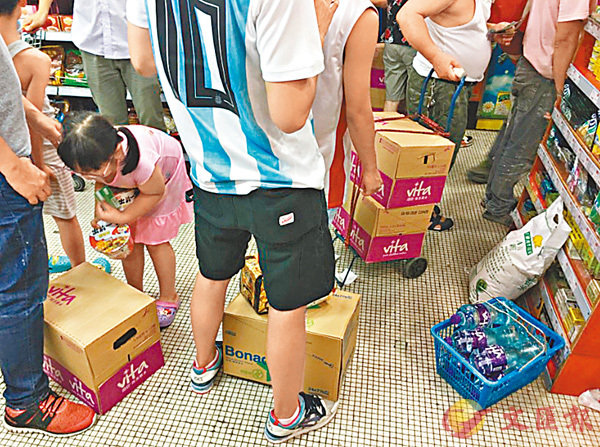 ■澳門居民全家總動員到超市購買樽裝水，以防打風「斷水」危機。