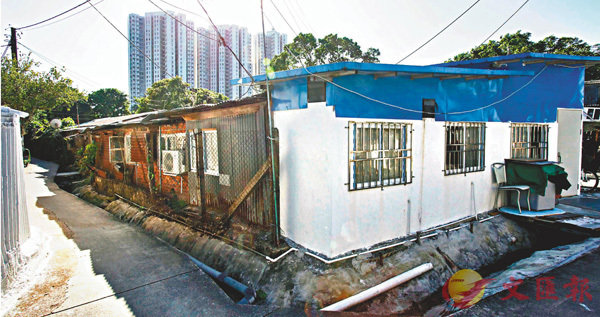 ■村中心的藍白色小屋屬非法擴建，緊接的一系列鐵皮屋和磚屋是違法改變用途，共�茈X20間�茤苤C 香港文匯報記者劉國權  攝