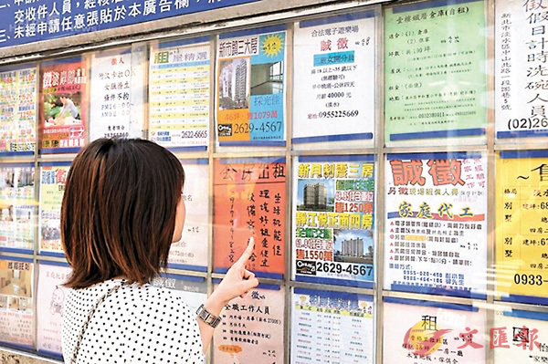 ■「韓流」帶動多數候選人推拚經濟，台灣樓市也因此看好選後行情。圖為女子在看房價廣告。 資料圖片
