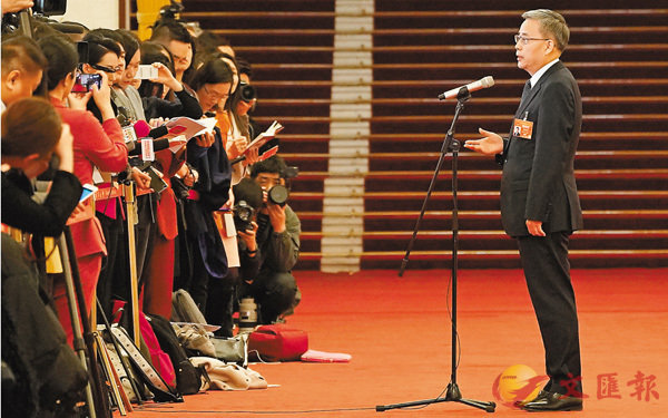 ■每年兩會，北京人民大會堂北大廳的「部長通道」總是最吸引媒體的地方。昨天郭樹清第一個踏上紅地毯走向採訪區回答媒體的提問。 新華社
