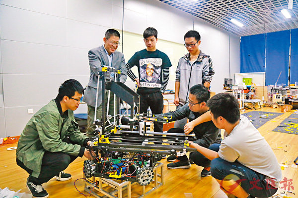 ■粵港機器人學院首席教授閻秋生（後排左）指導學生動手實操。 粵港機器人學院供圖