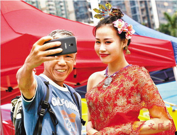 ■有市民與穿上泰國民族服飾的表演者自拍。香港文匯報記者劉國權  攝