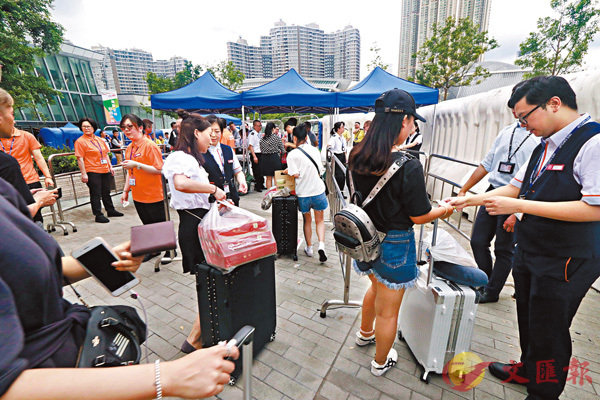 ■ 港鐵職員在西九站外檢查進站旅客。香港文匯報記者  攝