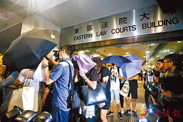  眾被告離開法庭時A紛紛用雨傘遮擋樣貌C 香港文匯報記者 攝