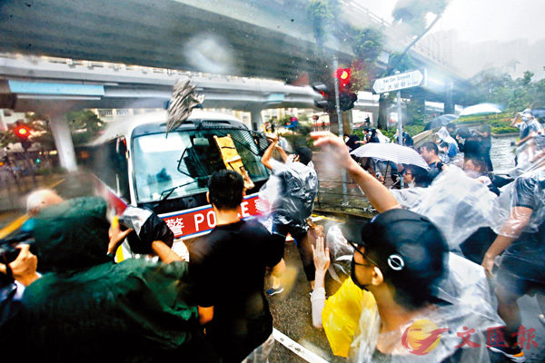  暴力示威者將雨傘擲向一輛警車A並拆毁警車的防護網C 香港文匯報記者 攝