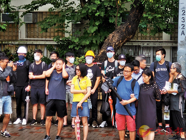■皇仁書院外有「暴徒裝」學生叫「港獨」口號，途人掩耳抗議。香港文匯報記者張得民 攝