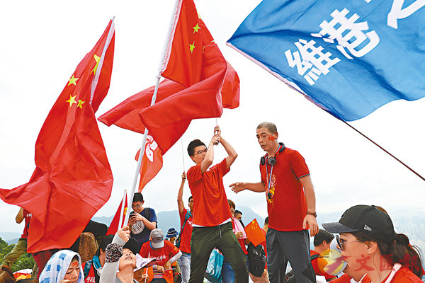 ■登山市民高舉五星紅旗和特區區旗。 香港文匯報記者 攝