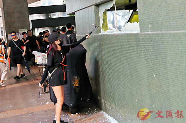 ■ 一名女暴徒參與搗毀灣仔地鐵站出口的玻璃。香港文匯報記者 攝