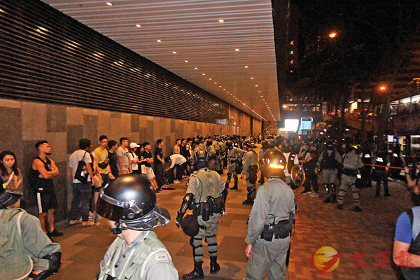 ■ 警方在灣仔港灣道截停隧巴，大批黑衣人被帶下車搜查。香港文匯報記者  攝