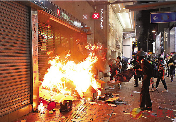 ■有黑衣暴徒威脅破壞商舖進行勒索。圖為10月4日晚，暴徒在港鐵站外縱火。 資料圖片