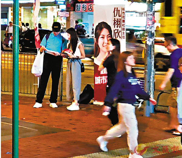■ 「素人」仇栩欣（白衣）在北角擺街站反應冷淡。 香港文匯報記者張得民  攝