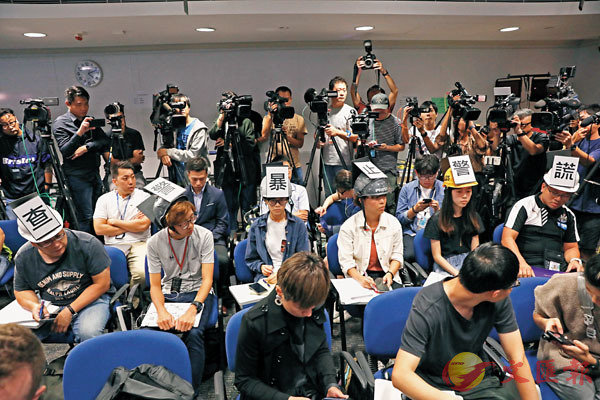 在警總舉行的例行記者會上A6名黃絲記者的頭盔前後貼上u查警暴E止警謊v6個大字C 香港文匯報記者 攝