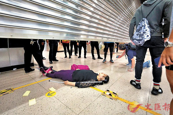 ■ 一名視障女士躺倒在地，圖阻止沙田港鐵站落閘。網上圖片