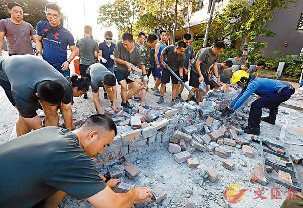 ■浸會大學外，市民、駐港部隊士兵及消防一起拆除堵路磚牆。 香港文匯報記者 攝