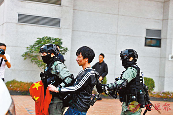 ■身穿運動外套的疑犯仍緊扯警員手中的國旗不放。 香港文匯報記者  攝
