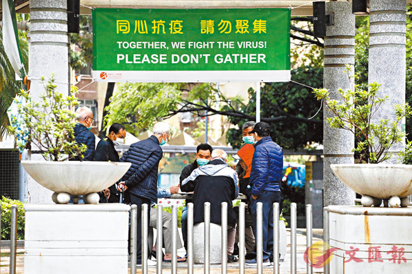 ■在深水�鶪@個公屋公園掛上了限聚橫額，4名長者玩牌，5人觀戰。 香港文匯報記者 攝
