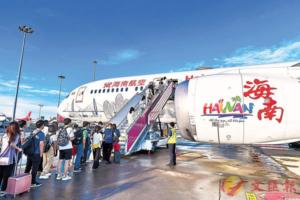 ■ 在深圳寶安國際機場，乘客登上「海南自貿港號」主題塗裝飛機。   香港文匯報深圳傳真