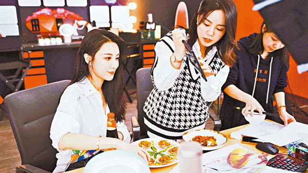 薇婭拿出李錦記的調味品，就�茞{場烹飪的蒜蓉扇貝向粉絲們介紹起做法來。香港文匯報記者俞晝  攝
