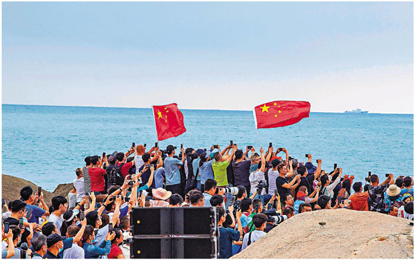 ● 民眾昨日在海南文昌淇水灣海邊觀看火箭升空。法新社