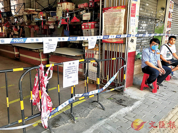 ● 廣州確診的75歲女性長者近日多次前往的菜市場昨日已封閉，門口有專人值守。 香港文匯報記者敖敏輝 攝