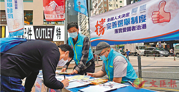●多位港區全國人大代表昨日強調，中國共產黨用「一國兩制」實現了香港的回歸，保障特區市民的基本權利。圖為今年3月，市民在灣仔街頭的街站簽名支持完善選舉制度。資料圖片